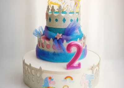 Torta a tema unicorno con glitter, coroncine e numero due rosa, perfetta per compleanni speciali in Abruzzo.