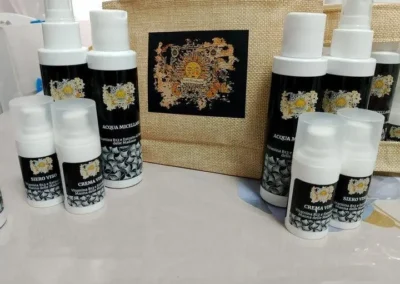 Set completo di prodotti cosmetici "L'oro dei Trabocchi" che include siero viso, crema viso e acqua micellare, disposti su un tavolo.