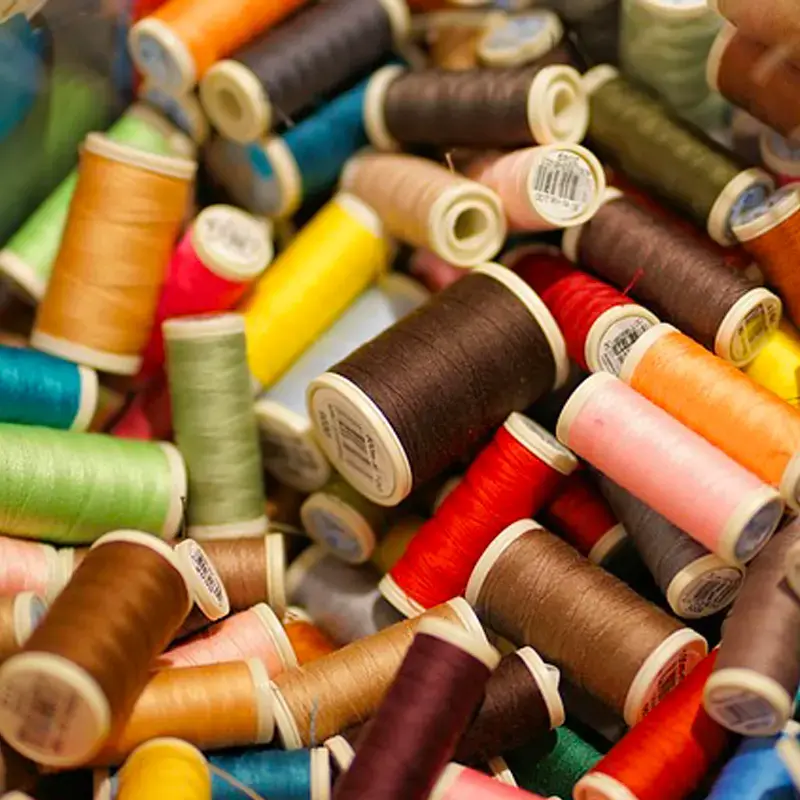 rocchetti di filo colorati per riparazioni sartoriali Rocchetti di filo da cucito di vari colori ammassati, ripresa ravvicinata